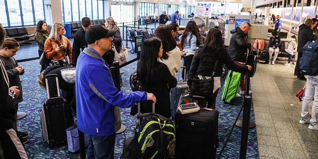 Passengers stand in line for a Frontier Airlines flight at Long Island MacArthur Airport in Ronkonkoma, New York, on February 22, 2023. 