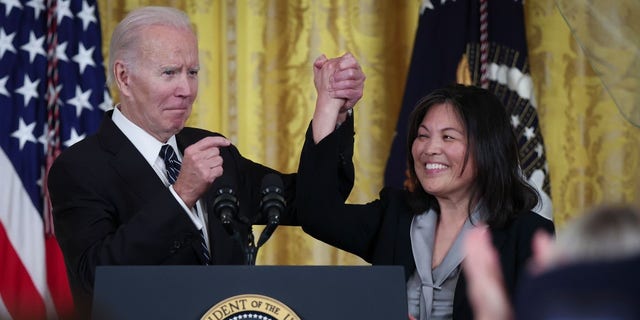 President Biden links arms with Julie Su, his nominee to be the next secretary of labor, during an event at the White House on March 1, 2023.