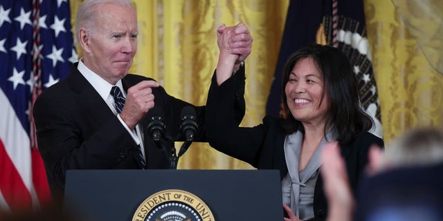 President Biden links arms with Julie Su, his nominee to be the next secretary of labor, during an event at the White House on March 1.