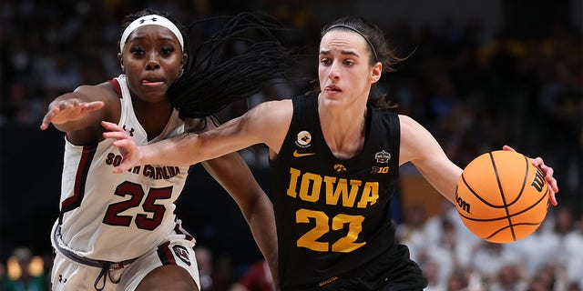Caitlin Clark (22) of the Iowa Hawkeyes dribbles against Raven Johnson (25) of the South Carolina Gamecocks during the third quarter of the 2023 NCAA Tournament Final Four at American Airlines Center March 31, 2023, in Dallas, Texas. 