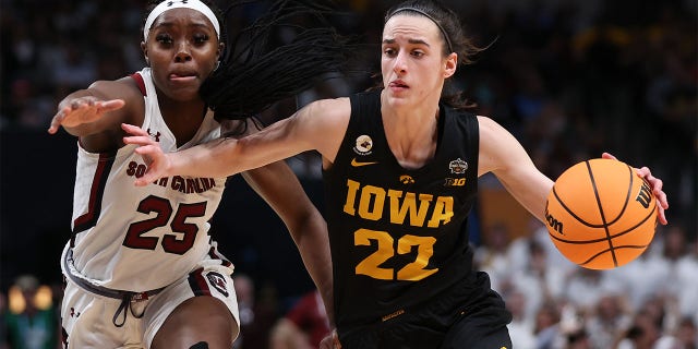 Caitlin Clark, #22 of the Iowa Hawkeyes, dribbles against Raven Johnson, #25 of the South Carolina Gamecocks, during the third quarter of the 2023 NCAA Women's Basketball Tournament Final Four semifinal game at American Airlines Center on March 31, 2023, in Dallas, Texas. 