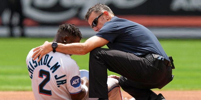 Miami Marlins assistant athletic trainer Ben Potenziano tends to Jazz Chisholm after he was injured trying to steal second base during the first inning against the Minnesota Twins at LoanDepot Park on April 5, 2023 in Miami, Florida. 