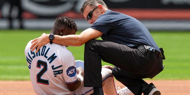Miami Marlins assistant athletic trainer Ben Potenziano tends to Jazz Chisholm after he was injured attempting to steal second base during the first inning against the Minnesota Twins at loanDepot Park April 5, 2023, in Miami, Fla.