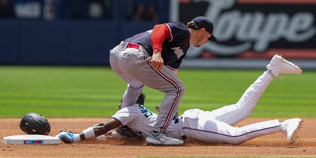 A sliding Jazz Chisholm Jr. of the Miami Marlins is tagged by Kyle Farmer of the Minnesota Twins while attempting to steal second base during the first inning against the Minnesota Twins at loanDepot Park April 5, 2023, in Miami, Fla.