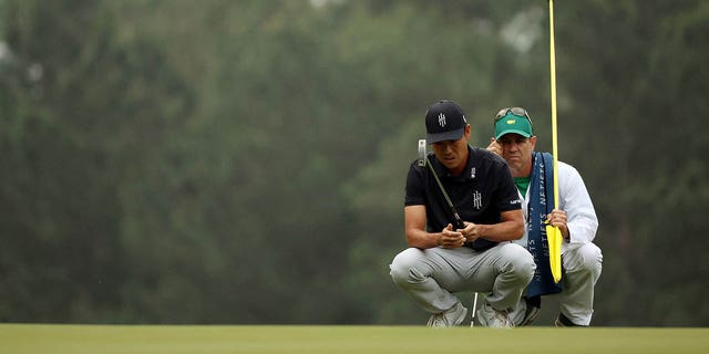 Kevin Na of the United States talks with his caddy Kenneth Harms on the third green during the first round of the 2023 Masters Tournament at Augusta National Golf Club on April 6, 2023 in Augusta, Georgia. 