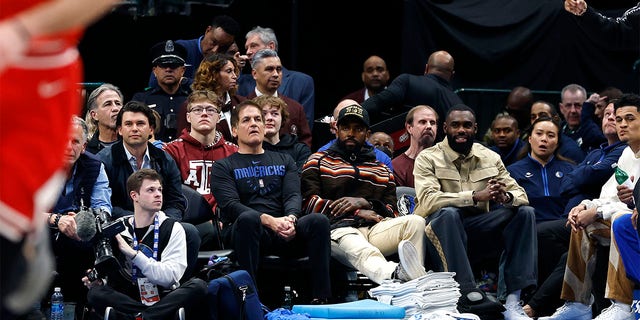 (L to R) Dallas Mavericks owner Mark Cuban, Kyrie Irving and Tim Hardaway Jr. sit court side during the game against the Chicago Bulls at American Airlines Center on April 7, 2023, in Dallas, Texas. 