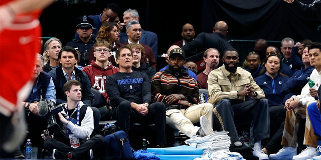 (L to R) Dallas Mavericks owner Mark Cuban, Kyrie Irving and Tim Hardaway Jr. sit court side during the game against the Chicago Bulls at American Airlines Center on April 7, 2023, in Dallas, Texas.