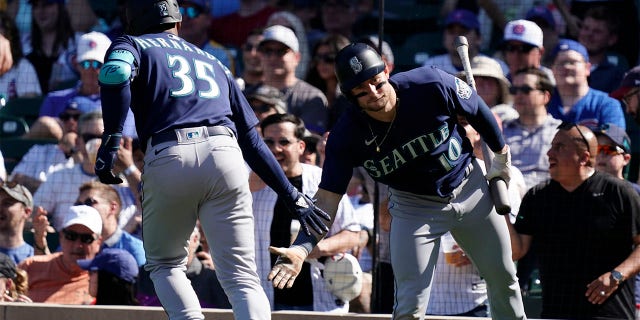 Teoscar Hernandez of the Seattle Mariners is congratulated by Jarred Kelenic during the Cubs game at Wrigley Field on April 12, 2023, in Chicago.