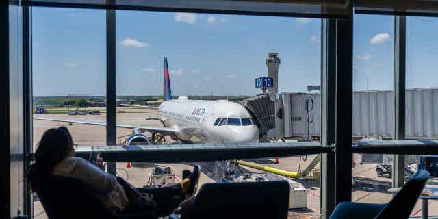 A passenger waits near a Delta Air lines terminal