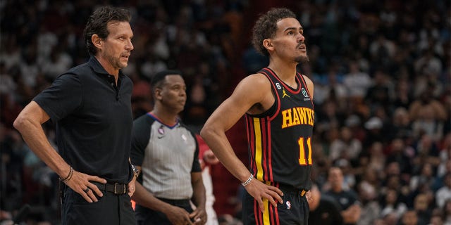 Atlanta Hawks head coach Quin Snyder, left, and Trae Young, #11 of the Atlanta Hawks, during a game against the Miami Heat at Kaseya Center on April 11, 2023 in Miami.