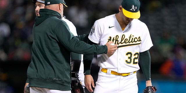 El manager de los Atléticos de Oakland, Mark Kotsay, toma el balón del lanzador abridor James Kaprielian, #32, y lo elimina del juego contra los Mets de Nueva York en la parte alta de la cuarta entrada en el RingCentral Coliseum el 14 de abril de 2023, en Oakland, California. 