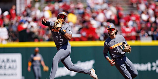 Christian Moore throws to first base