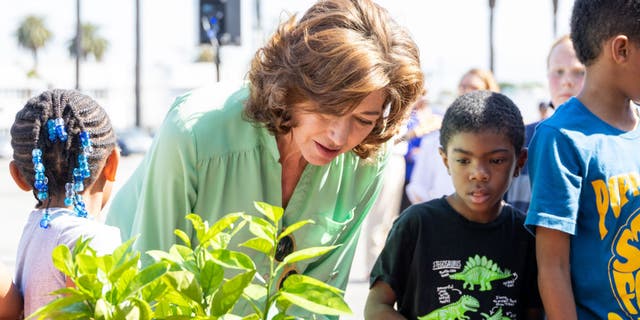 amy grant planting a tree with student