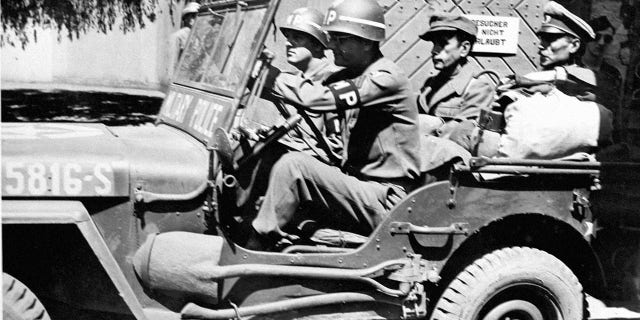 The former commander of the notorious German Buchenwald "horror" camp is taken away in a 15th U.S. Army jeep from Reinbach prison. Germany 1945.Â