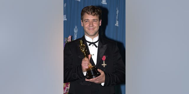 Russell Crowe holds his Oscar backstage in 2001