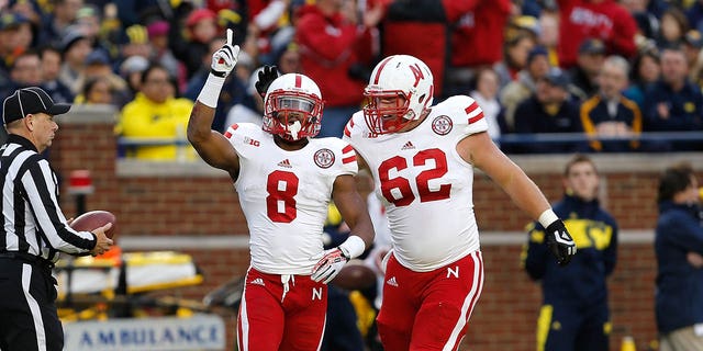 Ameer Abdullah (8) of the Nebraska Cornhuskers celebrates his first-quarter touchdown against the Michigan Wolverines with Cole Pensick (62) at Michigan Stadium Nov. 9, 2013, in Ann Arbor, Mich.