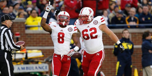 Ameer Abdullah (8) of the Nebraska Cornhuskers celebrates his first-quarter touchdown against the Michigan Wolverines with Cole Pensick (62) at Michigan Stadium Nov. 9, 2013, in Ann Arbor, Mich.