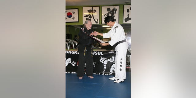 Nelson and Master Sam Um during Nelson's fifth-degree black belt award ceremony at Master Martial Arts in Austin, Texas, on April 28, 2014.