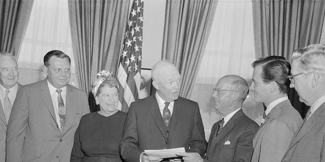 President Eisenhower in oval office with H.E. Humphreys, Jr., chairman of the board of the U.S. Rubber Company; and National Chairman of National Bible Week; and singer pat Boone, right, honorary co-chairman.