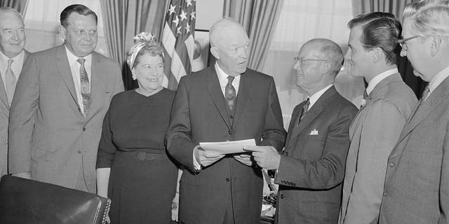 President Eisenhower in oval office with H.E. Humphreys, Jr., chairman of the board of the U.S. Rubber Company; and National Chairman of National Bible Week; and singer pat Boone, right, honorary co-chairman.