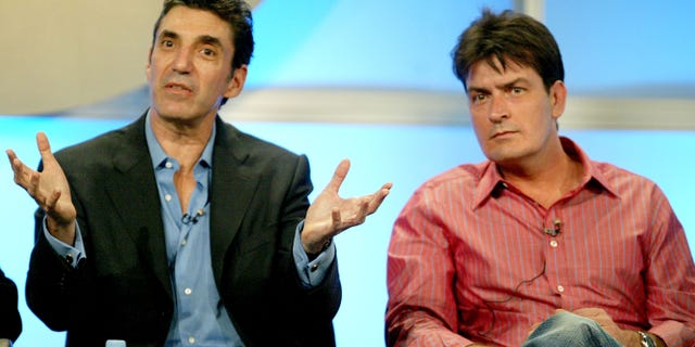 Chuck Lorre and Charlie Sheen sit next together on stage