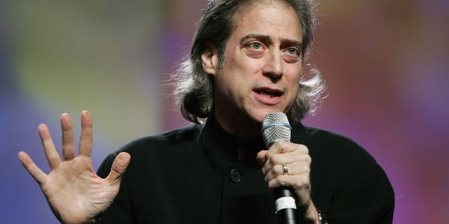 Richard Lewis with a microphone performing stand up