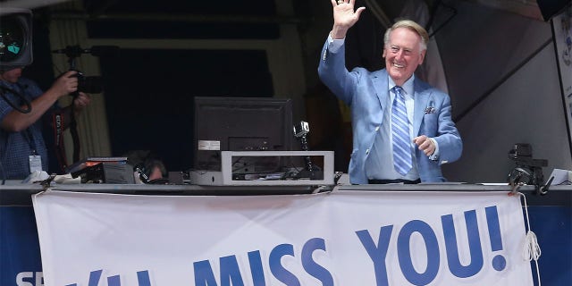 Los Angeles Dodgers broadcaster Vin Scully waves to the crowd after leading in the singing of "Take Me Out to the Ball Game" during the seventh inning stretch of the game with the Colorado Rockies at Dodger Stadium on September 24, 2016 in Los Angeles. The Dodgers won 14-1.