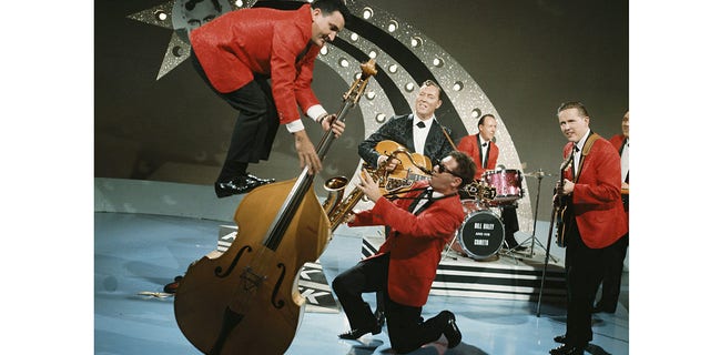 Bill Haley and His Comets, menampilkan Al Rappa berdiri di atas double bass-nya, tampil "Terima Bintang Keberuntungan Anda" Acara TV di Aston Studios pada bulan September 1964 di Birmingham, Inggris Raya.  Gambar adalah bagian dari Koleksi Premium David Redfern. 