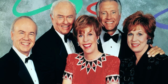 The Carol Burnett Show cast smiling while standing close to each other