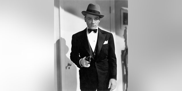 James Cagney in a suit and bow tie with a fedora holding a gun