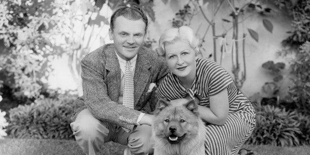 James Cagney posing for a photo with his wife and their dog