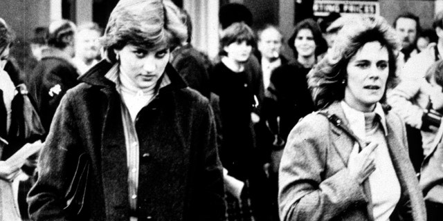 A black and white photo of Princess Diana walking alongside Camilla