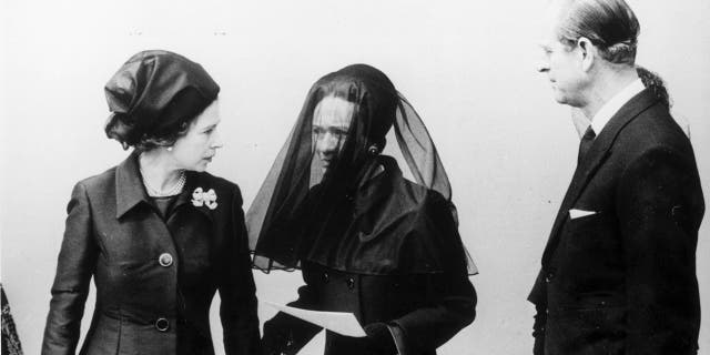 Queen Elizabeth II (left) and her husband Prince Philip (right) talking to the Duchess Of Windsor (center) after the Duke of Windsor's funeral. 