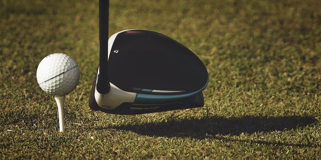Una vista general de una pelota de golf en un tee con un conductor