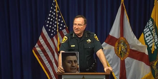 Polk County Sheriff (FL) Grady Judd holds picture of inmate who died