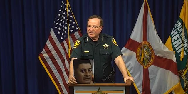 Polk County Sheriff (FL) Grady Judd holds picture of inmate who died