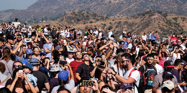 FILE - People attend a solar eclipse viewing event at the Griffith Observatory in Los Angeles, on Aug. 21, 2017.