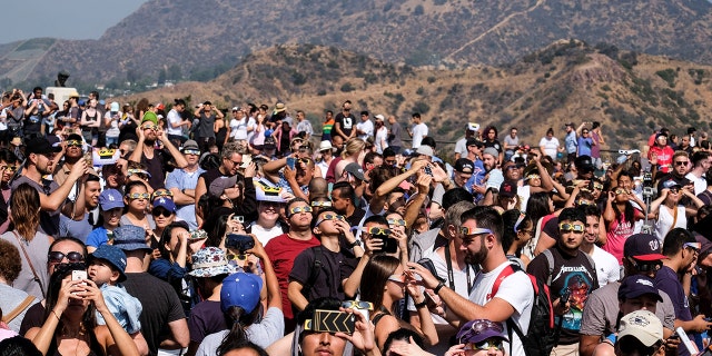 FILE - People attend a solar eclipse viewing event at the Griffith Observatory in Los Angeles, on Aug. 21, 2017.