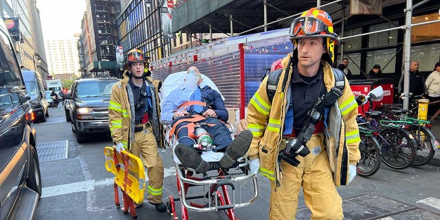 Paramedics transport a victim on a stretcher following a garage collapse at 57 Ann Street in New York City, Tuesday, April 18, 2023.