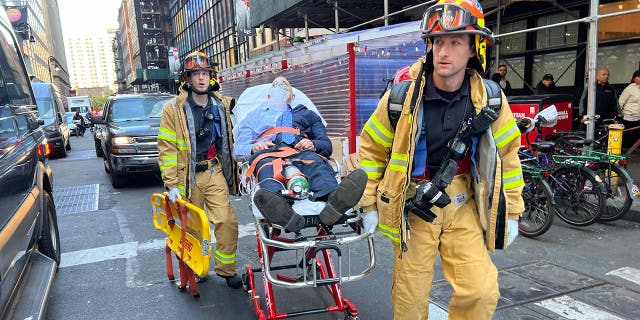 Paramedics transport a victim on a stretcher following a garage collapse at 57 Ann Street in New York City, Tuesday, April 18, 2023.