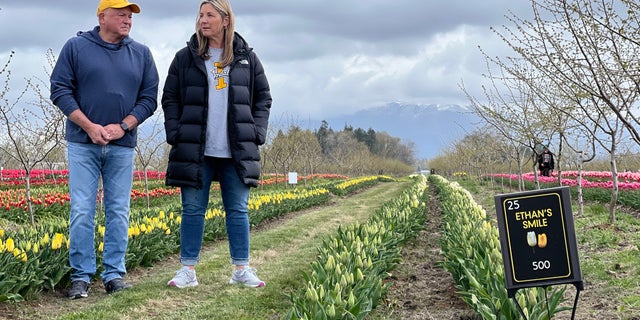 Ethan Chapin's parents standing near rows of flowers