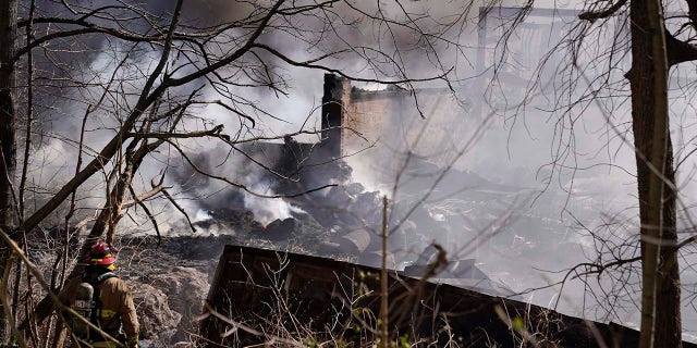 Firefighters continue to pour water on an industrial fire in Richmond, Indiana, Wednesday, April 12, 2023. Authorities urged people to evacuate if they live near the fire. The former factory site was used to store plastics and other materials for recycling or resale.