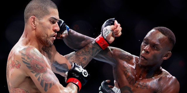 Israel Adesanya punches Alex Pereira in their middleweight title bout during UFC 287 at Kaseya Center on April 8, 2023, in Miami.