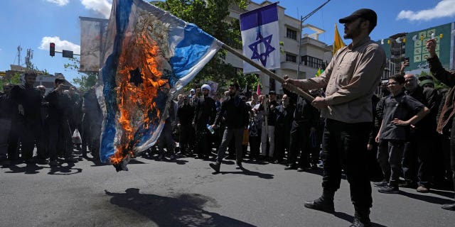 Iranian demonstrators burn a representation of the Israeli flag in their rally to mark Jerusalem Day, an annual show of support for the Palestinians, in Tehran, Iran, on April 14, 2023.