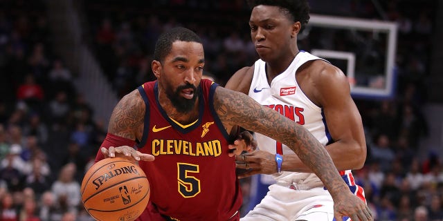 JR Smith #5 of the Cleveland Cavaliers tries to drive around Stanley Johnson #7 of the Detroit Pistons during the first half at Little Caesars Arena in Detroit, Michigan.