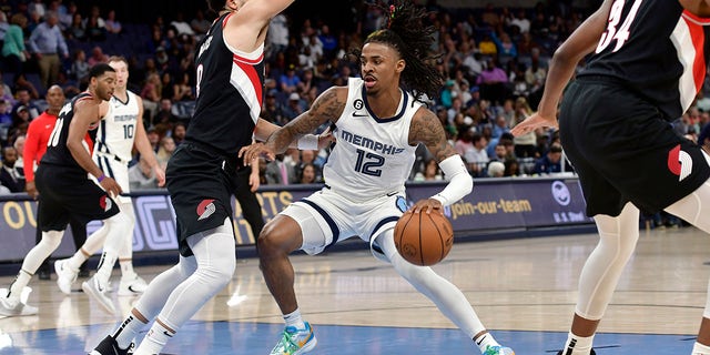Memphis Grizzlies guard Ja Morant, #12, handles the ball against Portland Trail Blazers guard Skylar Mays, #8, in the second half of an NBA basketball game Tuesday, April 4, 2023, in Memphis, Tennessee.