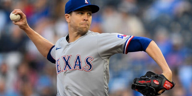 El lanzador abridor de los Rangers de Texas, Jacob deGrom, lanza a un bateador de los Reales de Kansas City en la primera entrada de un juego de béisbol, el lunes 17 de abril de 2023, en Kansas City, Missouri.