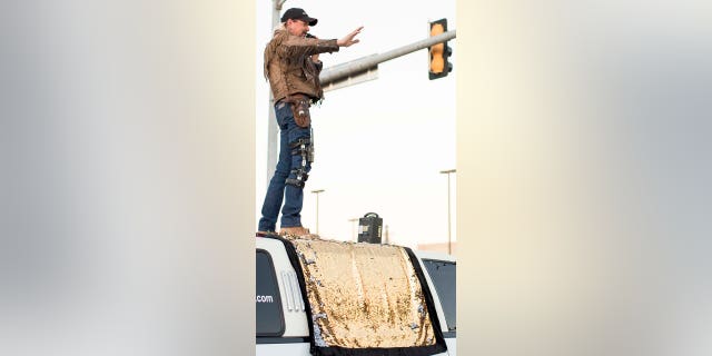 Joseph Maldonado, known as "Joe Exotic", waves from the top of a limousine