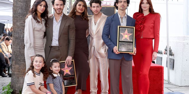 Danielle Jonas, Kevin Jonas, Priyanka Chopra, Nick Jonas, Joe Jonas, Sophie Turner, and (front) Alena Rose Jonas and Valentina Angelina Jonas attend The Hollywood Walk of Fame star ceremony honoring The Jonas Brothers on January 30, 2023 in Hollywood, California. 