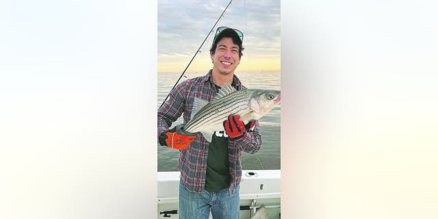 Jonathan Honey holds a freshly caught fish